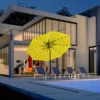 9ft Round Tilt Patio Umbrella with Solar LED Light-Yellow at night by the poolside