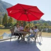 A family having lunch under the 11ft Round Curved Offset Hanging Umbrella with Base-Red