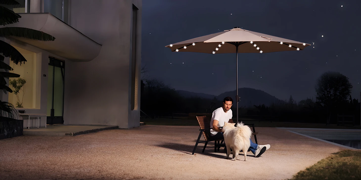 A man under the Round Tilt Patio Umbrella with Solar LED Light