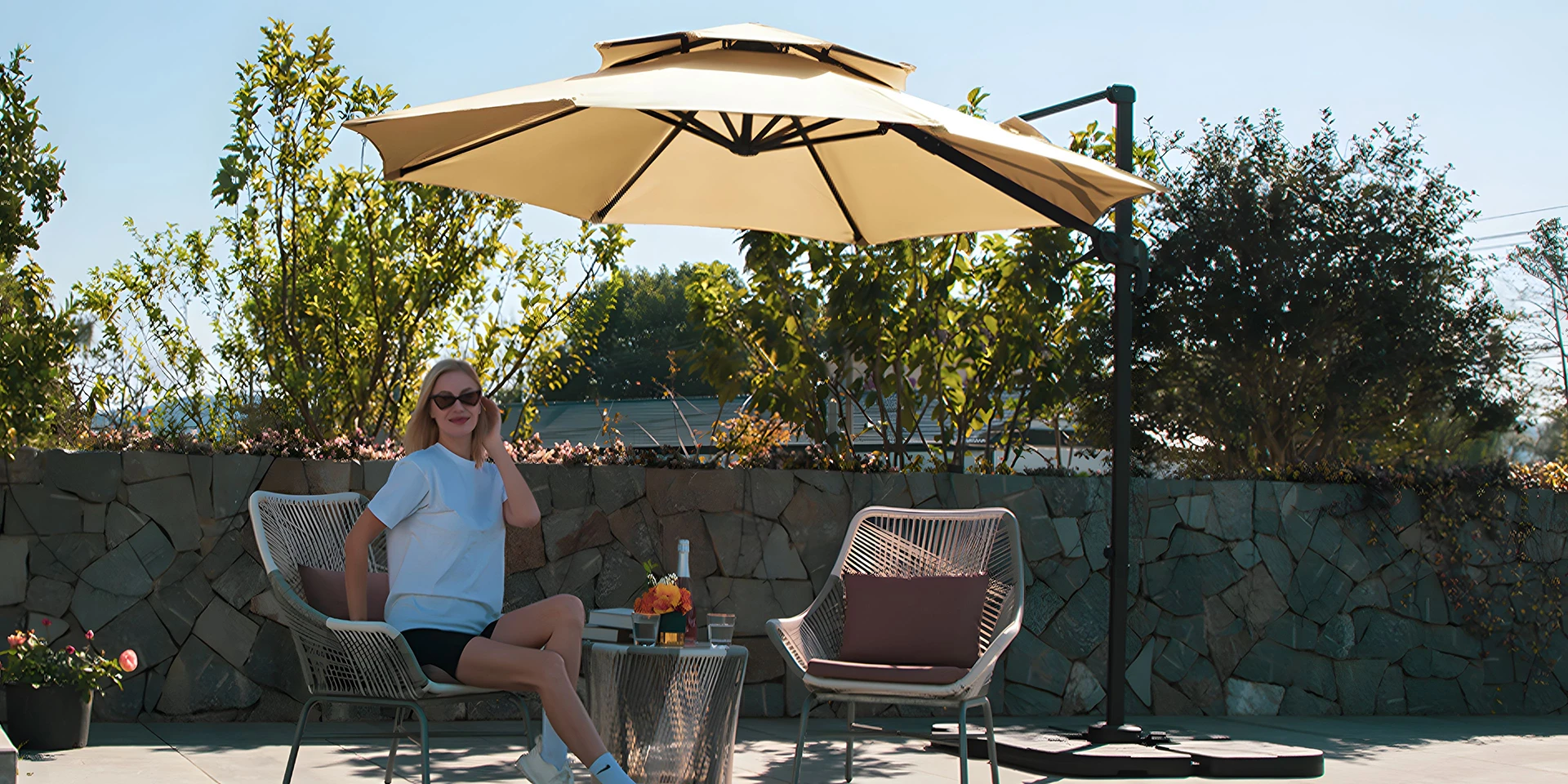 A young female sitting in the shade of the 11 ft Cantilever Umbrella.