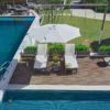 Olefin 10ft Round Auto Tilt Patio Umbrella-Creamy White by the poolside