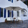 Olefin 10ft Round Auto Tilt Patio Umbrella-Creamy White with outdoor chairs set on the front porch