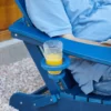 A cup of juice on the cup-holder of the HDPE 5-Piece Reclining Adirondack Chair Conversation Set-Navy Blue