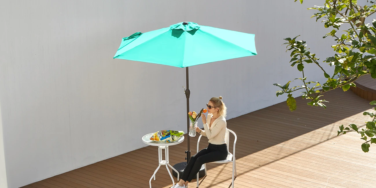 A woman enjoy tea under 7.5 ft Round Tilt Patio Umbrella