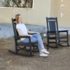 A woman resting on the Classic Porch Presidential Rocking Chair-Black