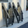 HDPE Reclining Folding Adirondack Chair with Ottoman-Dark Gray folded and placed against the wall