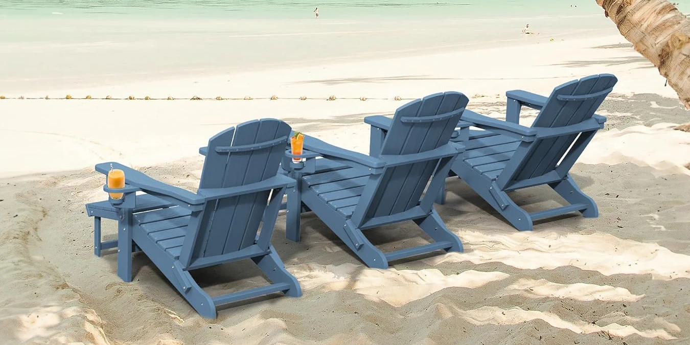There is a row of blue folding adirondack chair with footrest on the beach.