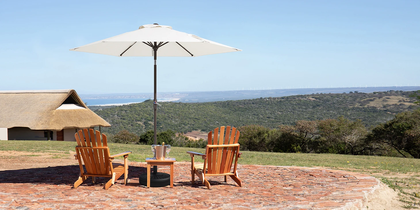 Round Tilt Patio Umbrella with two adirondack chairs