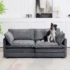 A dog standing on a gray modern sofa loveseat
