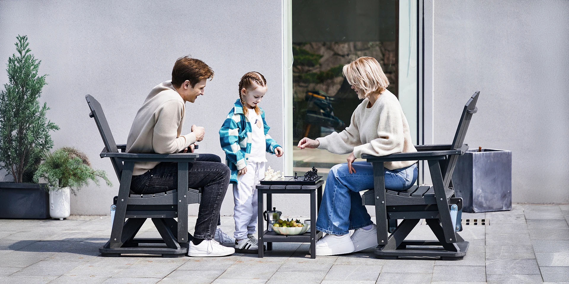 Happy Family Sitting on the Outdoor Adirondack Swivel Glider Chairs